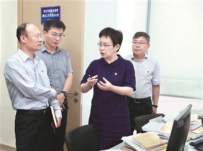 圖為孫英（右二）與同事一起分析研判某案件問(wèn)題線索。（江蘇省無(wú)錫市紀(jì)委監(jiān)委供圖）